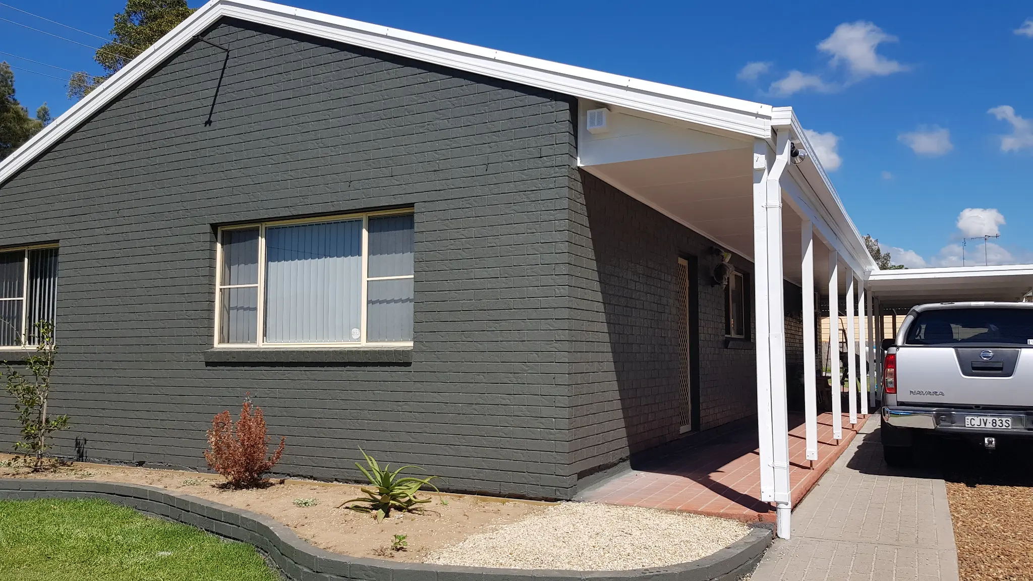 Brick house after painting in modern grey
